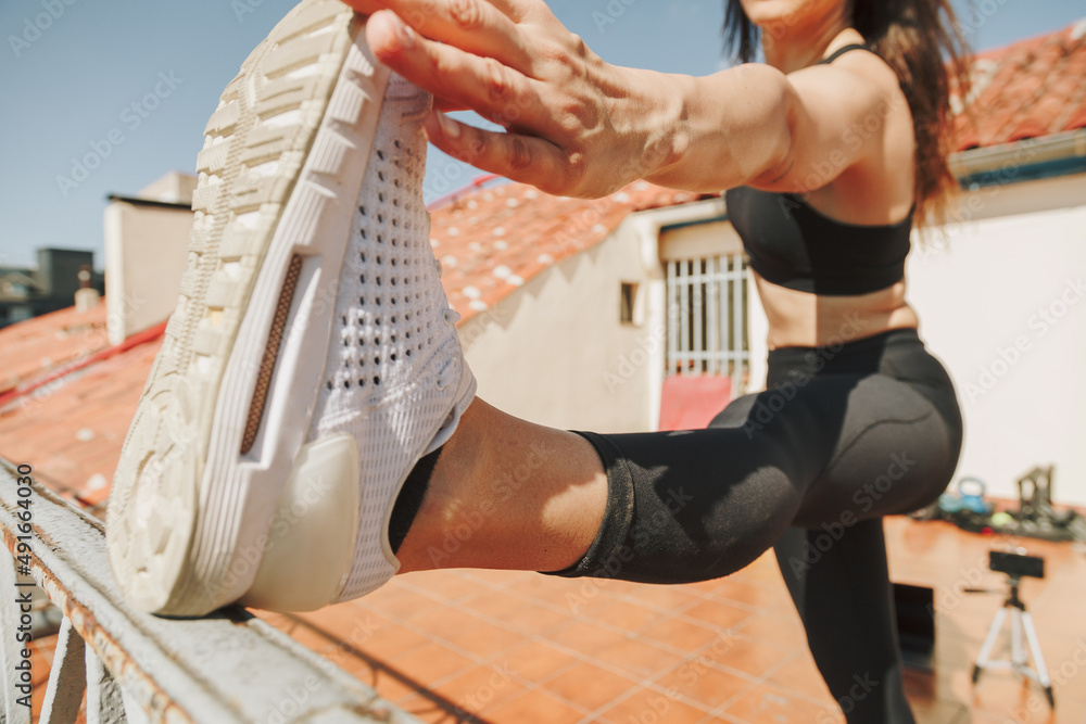 Sportwoman stretching on a rooftop. Healthcare lifestyle concept.