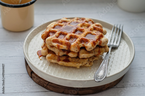 Waffles with caramel sauce. Wooden background. Top view. 