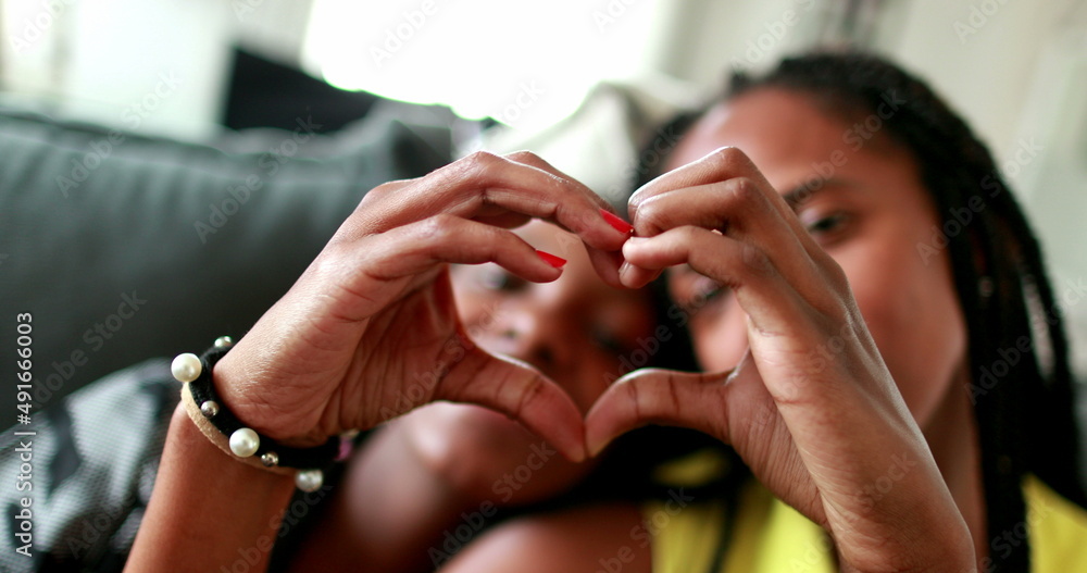 Mother and daughter making heart symbol with hands. Black African ethnicity