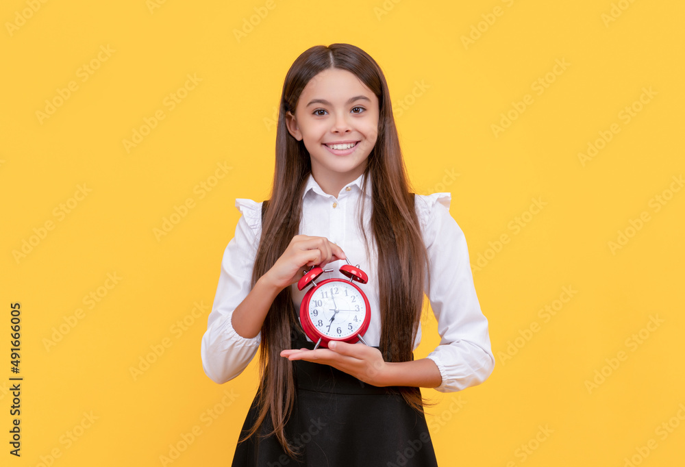 punctual teen girl checking time. happy child with alarm clock. school kid in uniform showing time punctual teen girl checking time. happy child with alarm clock. school kid in uniform showing time
