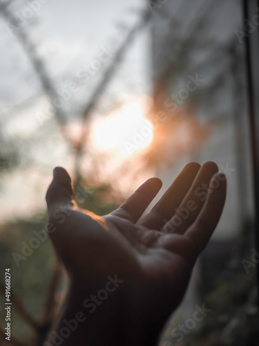 The hand held onto the light of the sun as if there was hope.