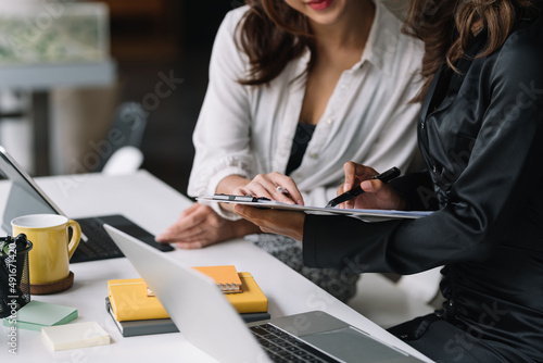 Two businesswoman sitting planning analyze investment and marketing on the desk in the office.