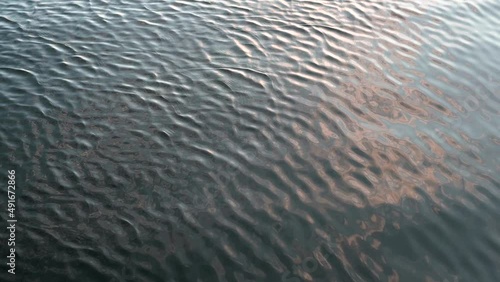Slow Motion of small waves refelcting the sunset