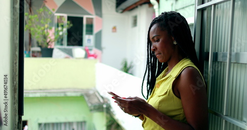 Candid black African woman checking cellphone at home
