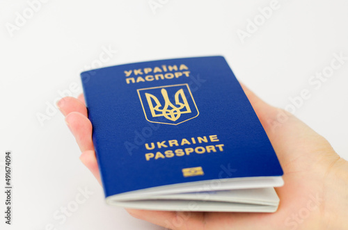 Ukrainian passport in a female hand on a white background, selective focus