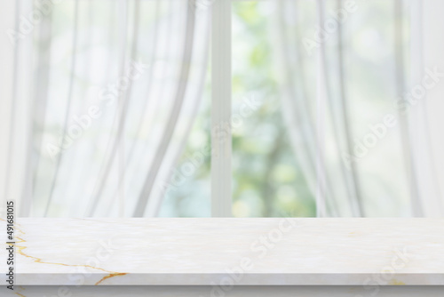 Marble table top on blur room interior with window curtain background © Piman Khrutmuang