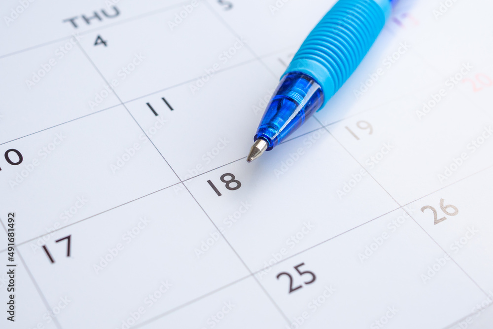 Blue pen on calendar page background business planning appointment meeting concept Blue pen on calendar page background business planning appointment meeting concept