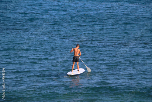 Man on stand up paddleboard (SUP) paddling at the Atlantic ocean  (Tenerife, Spain)