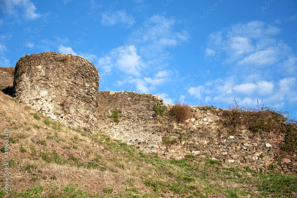 Fortress ancient wall against the background of a blue sky with white clouds. The topic of traveling to historical places in Europe. Fortress ancient wall against the background of a blue sky with white clouds. The topic of traveling to historical places in Europe.