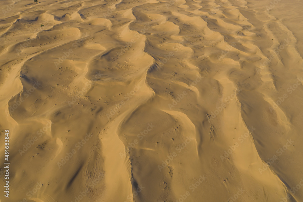 Aerial view of sand dunes in the desert at sunset, Dubai, United Arab Emirates. Aerial view of sand dunes in the desert at sunset, Dubai, United Arab Emirates.