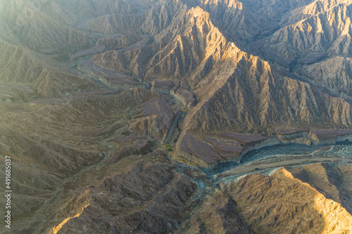 Aerial view of a canyon among the rocky and dry mountains in the desert in Ajman State, United Arab Emirates.