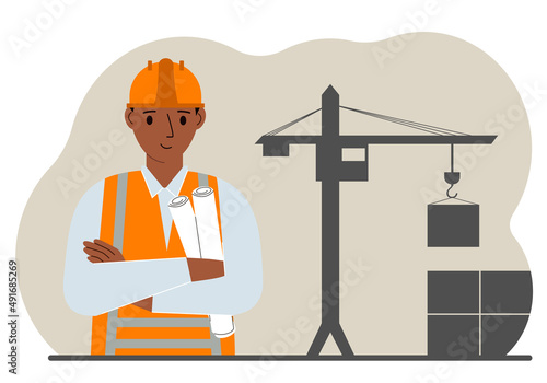 Happy engineer near the construction crane. Builder holding blueprints near construction machinery.