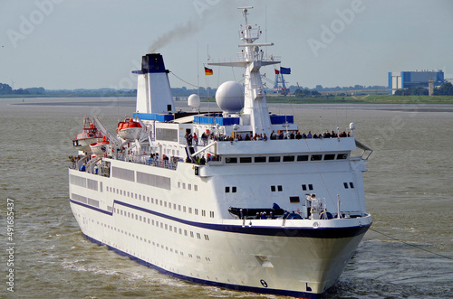 Classic cruiseship cruise ship liner Berlin in Bremerhaven port with infrastructure, terminal and other ships on sunny day with blue sky and close up details of vessel superstructure and funnel photo