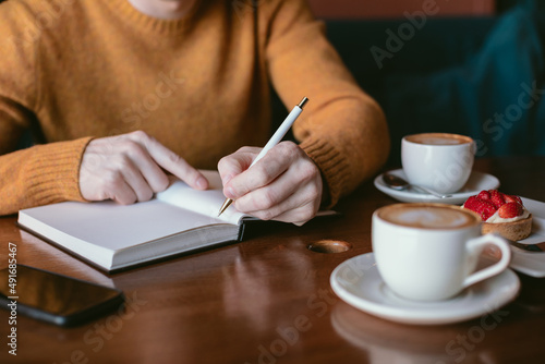 Man working and drinking coffee in a cafe. 