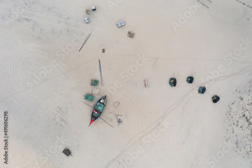 Aerial view of people along the shoreline prating the Arte Xavega, a Portuguese traditional fishing technique in Torreira, Portugal. photo