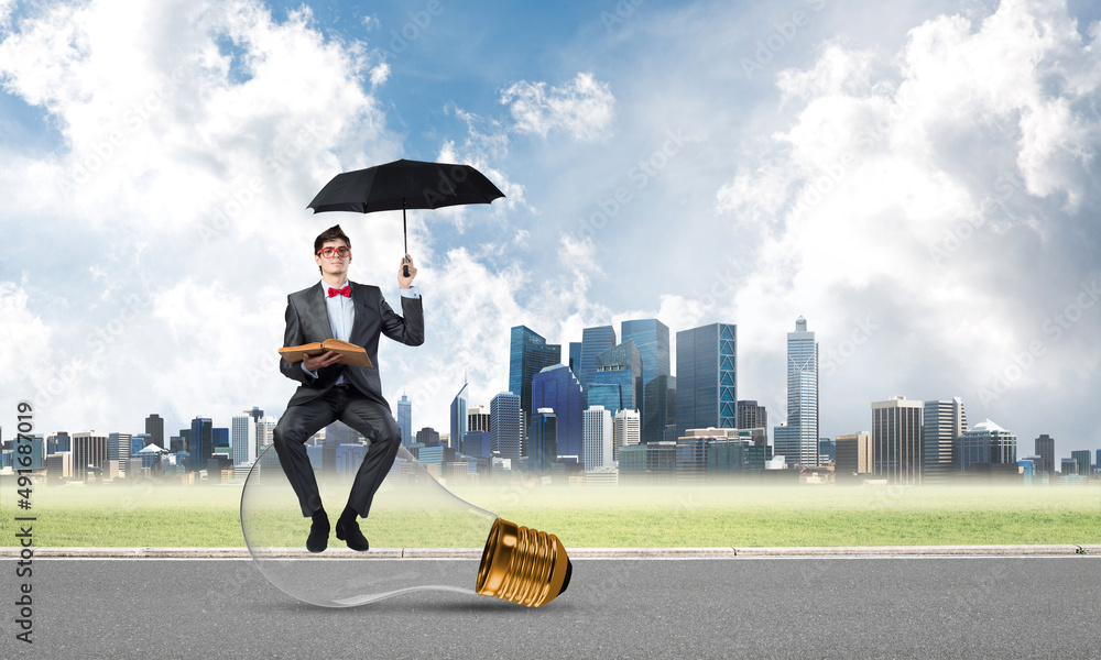 young businessman with umbrella and a book young businessman with umbrella and a book