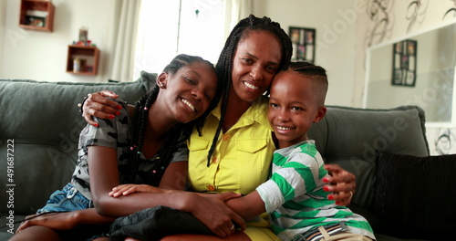 African mother embracing teen daughter and little boy son. African black ethnicity, love and affection © Marco