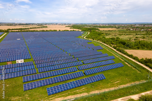 Aerial view of big sustainable electric power plant with many rows of solar photovoltaic panels for producing clean ecological electrical energy. Renewable electricity with zero emission concept.