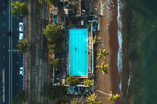 Aerial top down view of public open air swimming pool on the beach in Wellawatte district, Colombo city, Sri Lanka.
