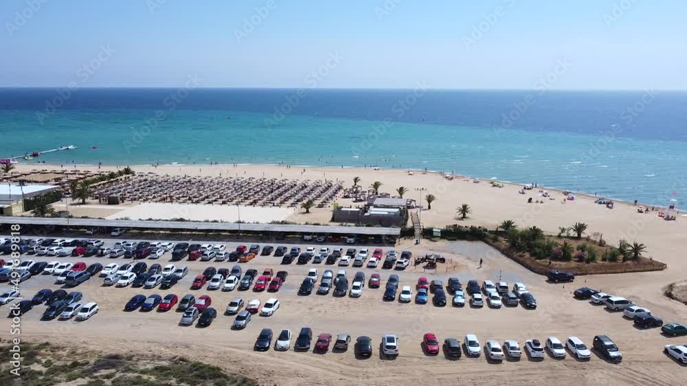 Luxury vacation beach resort with card parked on parking. Busy sunny weekend day on the beach Luxury vacation beach resort with card parked on parking. Busy sunny weekend day on the beach
