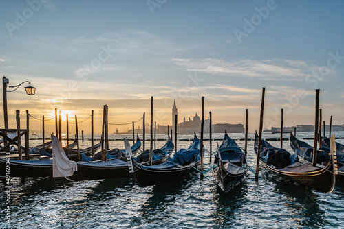 Venice,Italy.Famous canal and traditional gondolas,San Giorgio Maggiore church in background.Venetian city lifestyle,travel scenery.Architecture and landmark of Venezia.Water transport,sunny morning