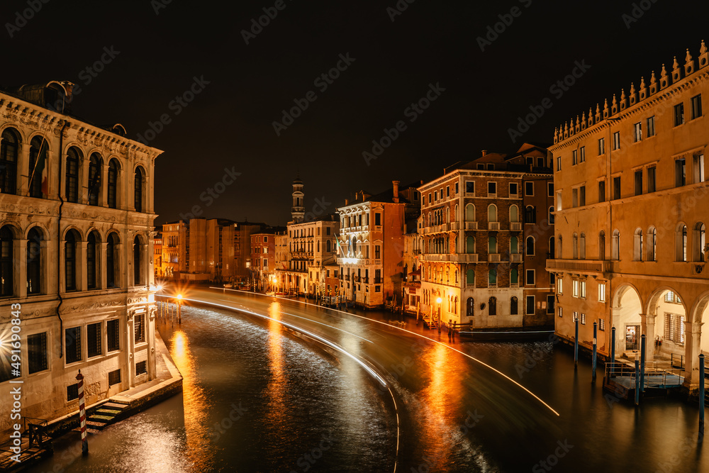 Grand Canal at night,Venice,Italy.Typical boat transportation,Venetian public waterbus long exposure.Water transport.Travel urban scene.Popular tourist destination.Old houses,hotels along canal