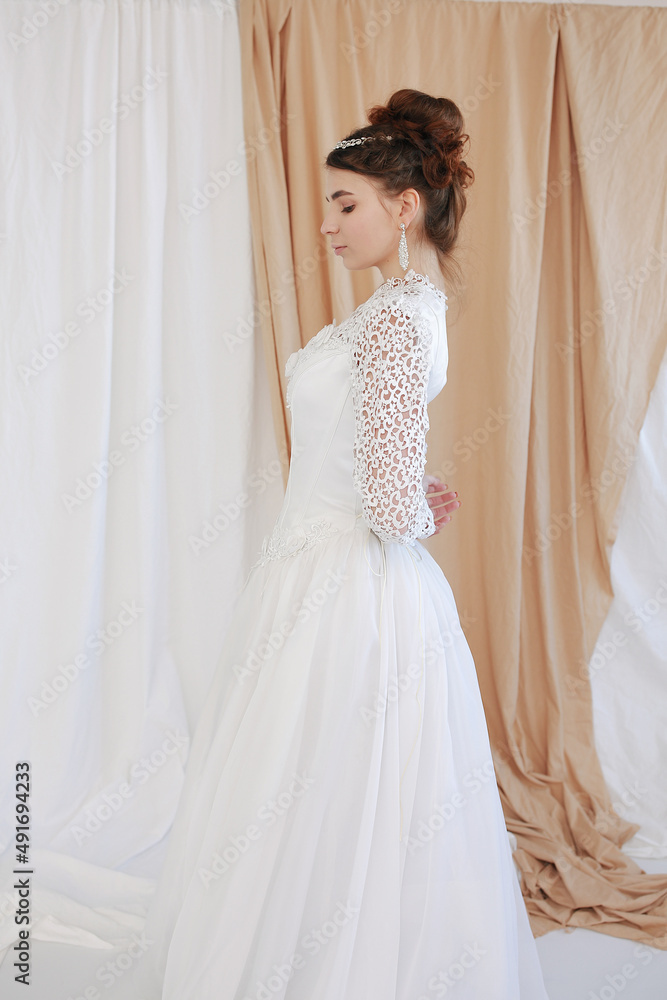 girl in a white wedding retro dress. wedding dress and hairstyle in the style of the 90's. Studio photo shoot in my mother's wedding dress. Bride photo shoot in the studio girl in a white wedding retro dress. wedding dress and hairstyle in the style of the 90's. Studio photo shoot in my mother's wedding dress. Bride photo shoot in the studio