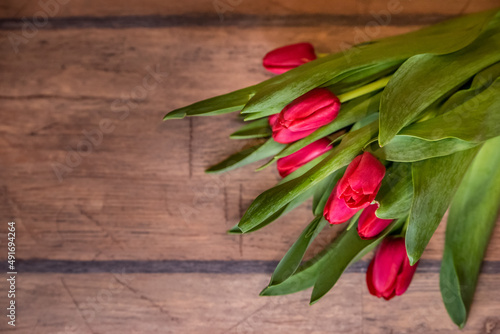 Fototapeta Naklejka Na Ścianę i Meble -  Red tulips on a wooden background, copy space