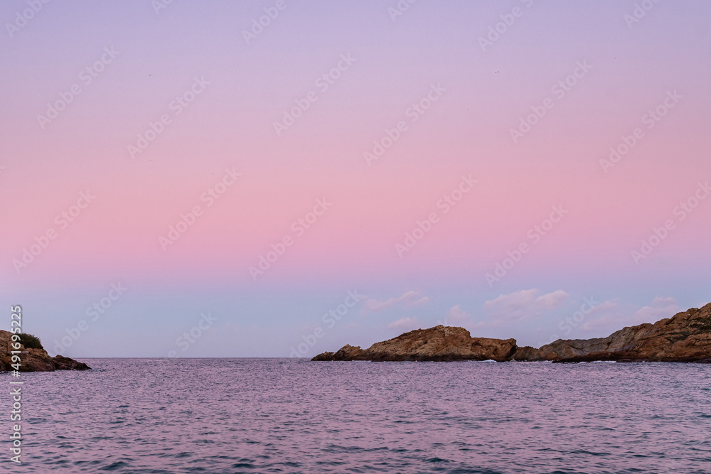 Rippling sea with rocky coast in twilight Rippling sea with rocky coast in twilight