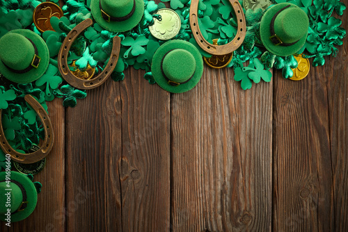 St Patricks Day border of shamrocks and coins over a rustic wood background