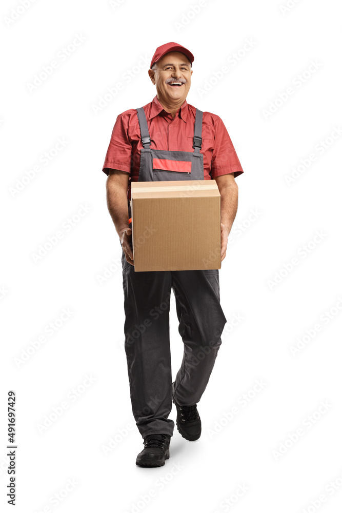 Cheerful mature delivery man walking and carrying a cardboard box Cheerful mature delivery man walking and carrying a cardboard box