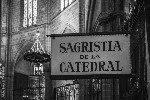 a sign from the cathedral of Barcelona gives directions to the sacristy
