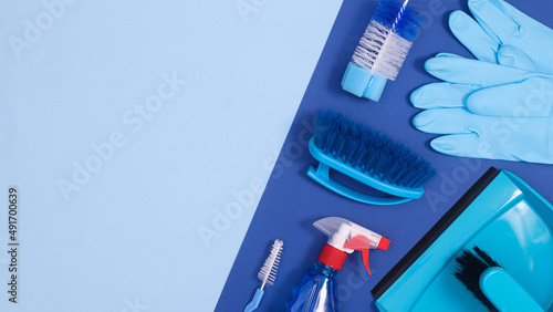 Cleaning tools on deep and pastel blue background with copy space. Flat lay