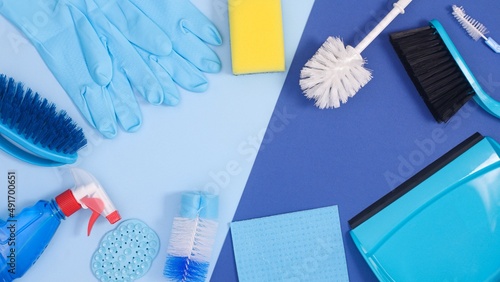 Creative copy space frame background with cleaning tools on pastel and deep blue theme. Flat lay