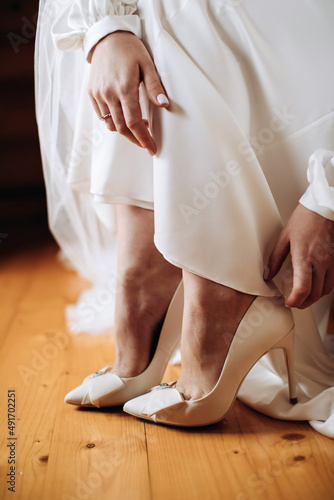 Bride puts on her shoes in the morning. Wedding day