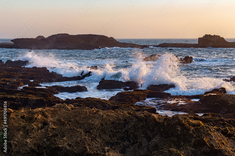 View of the volcanic shore of the Atlantic Ocean in the area of the city of Essaouira in Morocco on a summer evening. View of the volcanic shore of the Atlantic Ocean in the area of the city of Essaouira in Morocco on a summer evening.