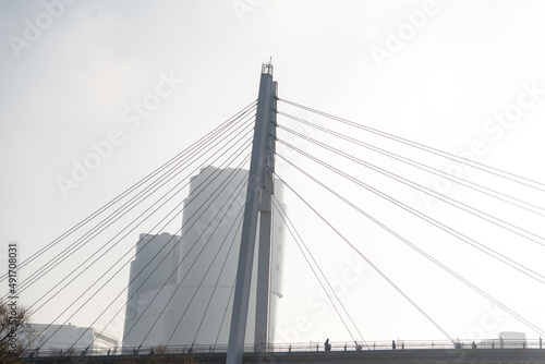 bridge over the river in the fog. People walk on a suspension bridge
