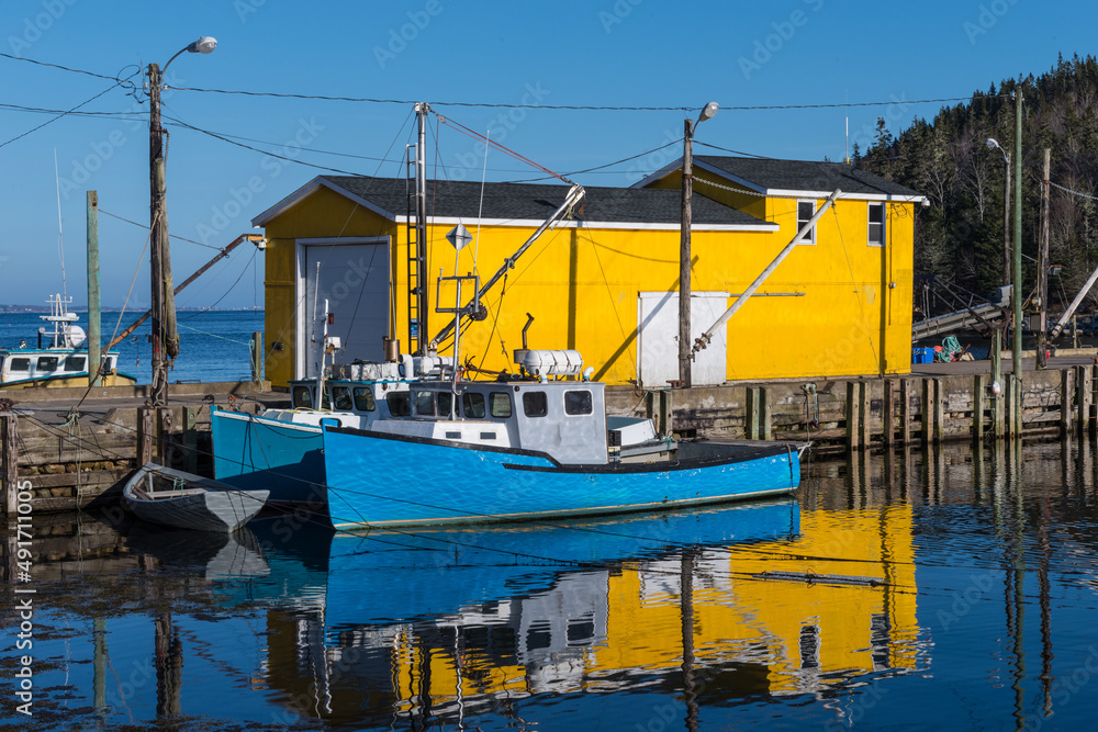 Lobster Fishing Cove  with boats on a bright summer day with Blue Sky and Yellow Building