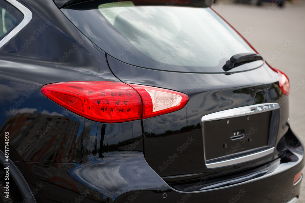 Back view of new black car. Closeup headlights of car. Black premium city crossover, luxury SUV rear light closeup. Car lamp close-up.