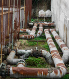 Old rusty big pipes and valves on ground