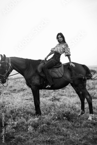 Girl with long black hair in the countryside. Ipadrome with horses. Rural landscapes, wild west.