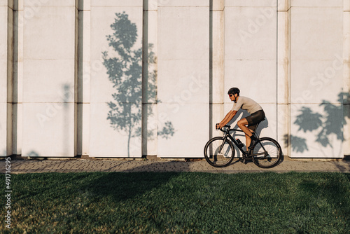 Caucasian man in sport clothes riding bike on city street