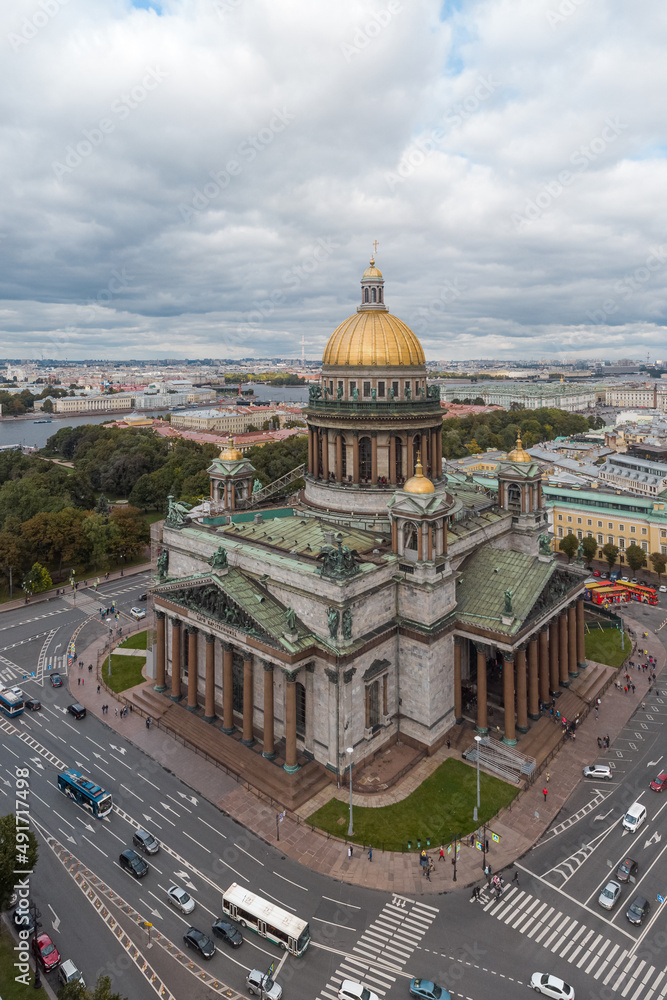 Vertical aerial photo of Saint Isaacs Cathedral in Saint Petersburg. Large orthodox church with golden dome and colonnade. Travel destination. Cloudy sky. Vacation concept.