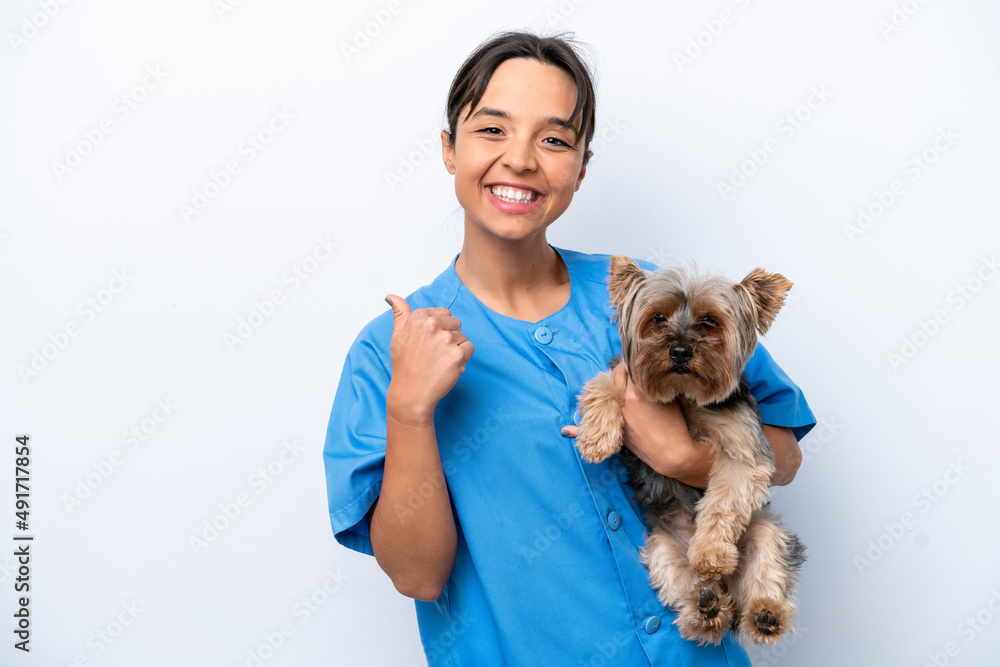 Young veterinarian woman with dog isolated on white background pointing to the side to present a product Young veterinarian woman with dog isolated on white background pointing to the side to present a product