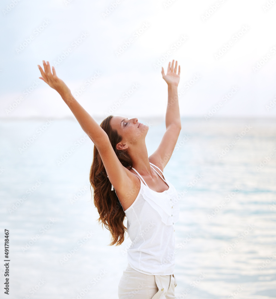 Finding release. Shot of a beautiful young woman with her arms raised to the sky. Finding release. Shot of a beautiful young woman with her arms raised to the sky.