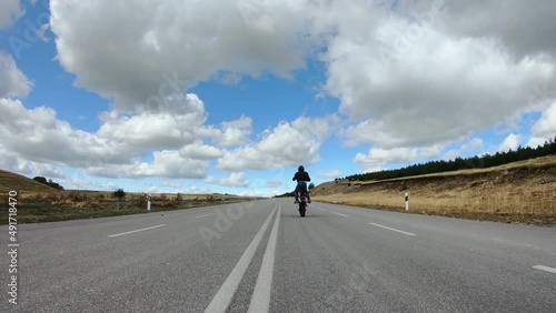 Biker stunt ride biike on mountain rural road and do wheelie on motorcycle photo