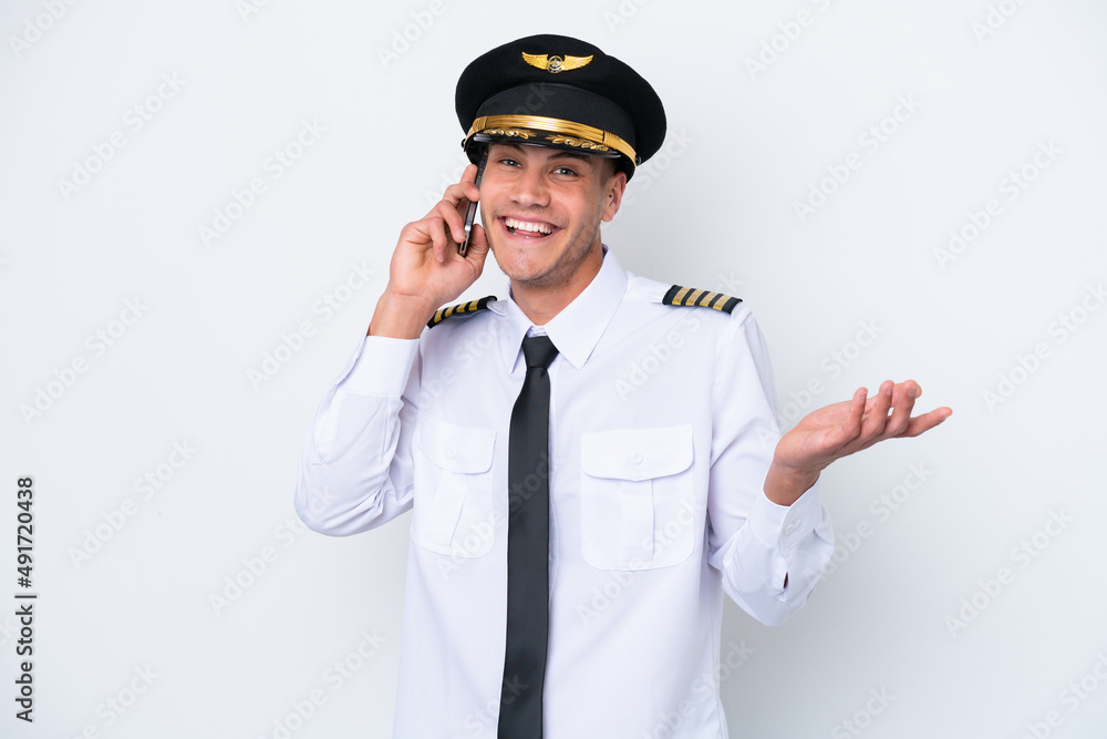 Airplane caucasian pilot isolated on white background keeping a conversation with the mobile phone with someone