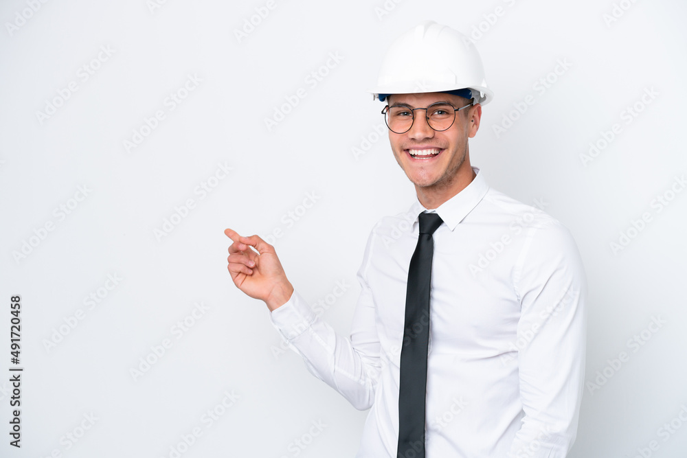 Young architect caucasian man with helmet and holding blueprints isolated on white background pointing finger to the side Young architect caucasian man with helmet and holding blueprints isolated on white background pointing finger to the side