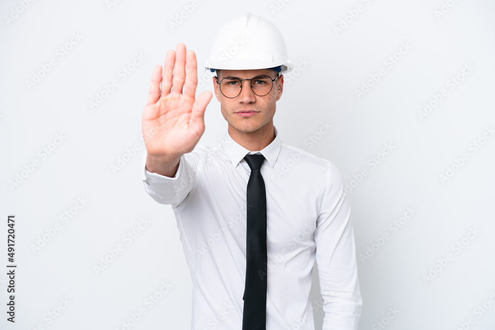 Young architect caucasian man with helmet and holding blueprints isolated on white background making stop gesture Young architect caucasian man with helmet and holding blueprints isolated on white background making stop gesture
