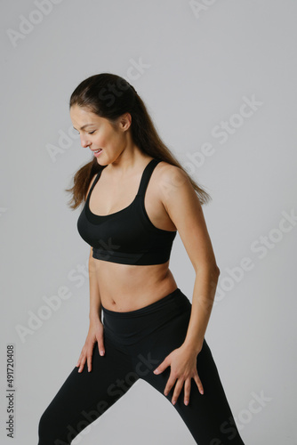 Sporty young woman doing exersises on white background. Vertical.
